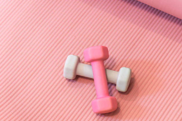 istock Rubber coated dumbbells on pink yoga mat 1669085021