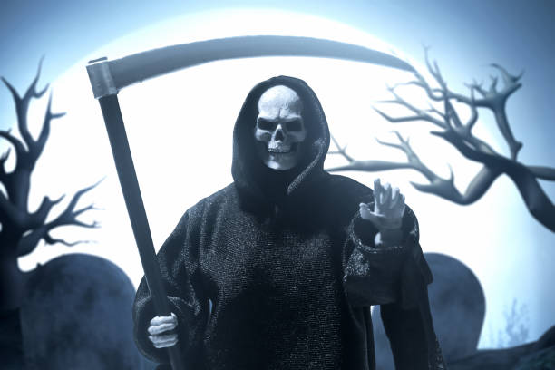 istock Grim reaper with scythe on graveyard cemetery with full moon background 1669118662