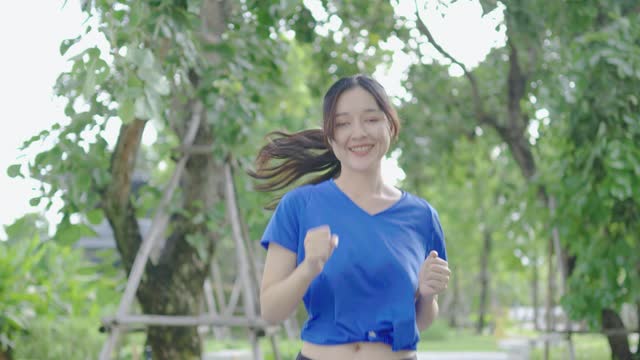 Young asian woman runner training in summer park. Close up fitness girl jogging outdoor. Morning running concept, healthy way of life, staying fit concept, slow motion 4k