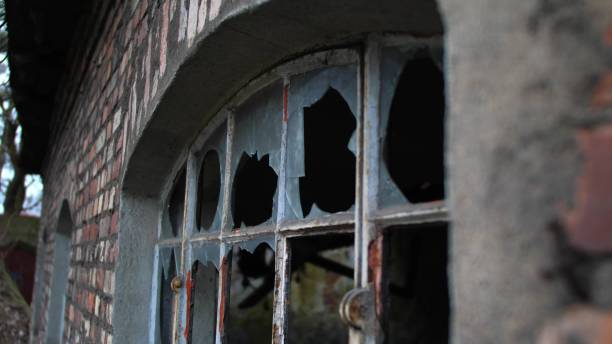 istock Broken Windows in Abandoned Industrial Warehouse Factory Brick Building 1669211270