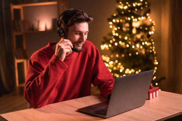 istock Young hispanic call center agent man using laptop sitting on the table at home. Christmas distance work 1669253775