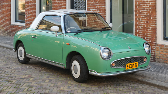 A pastel green Nissan Figaro in a street in the Netherlands. Only 12000 Nissan Figaro's were produced in Japan.