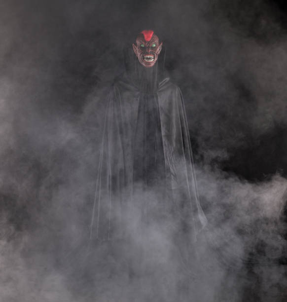 istock vampire in a black cloak on a black background 1669256451