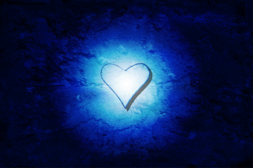 Horizontal vector illustration of an abstract light blue circular shaped light in the middle of dark navy and royal blue gradient colour gradient vector backgrounds. Looks like water central to ice or nebula in outer space. There is a heart in the centre, making it at for romance, love and Valentine related backgrounds.