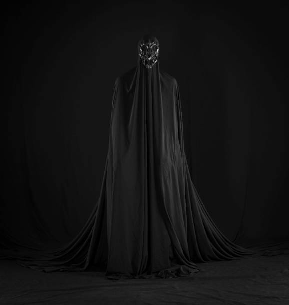 istock witch in a black cloak on a black background 1669261228