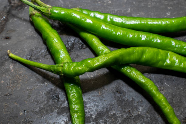istock Fresh green peppers or chillies placed on a black background 1669263884