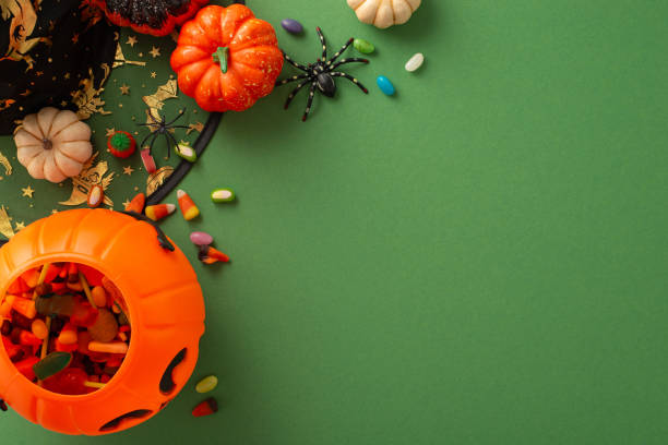istock Embark on a journey of Halloween celebration delight with this top view image highlighting witch attributes, Halloween decorations on green isolated backdrop, offering ample space for text or adverts 1669270814
