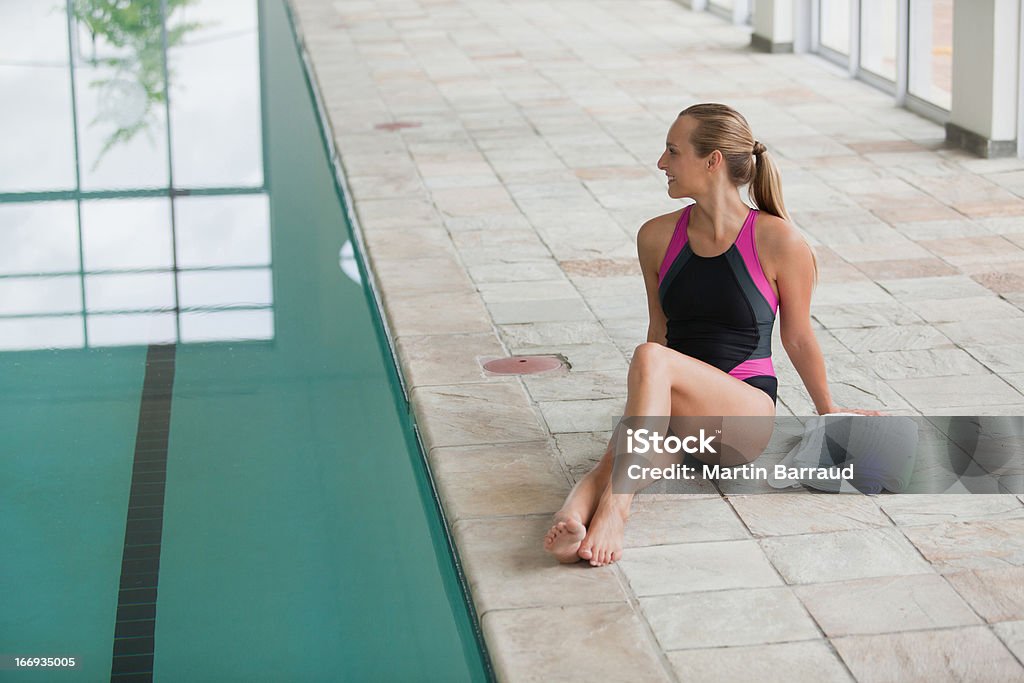 Retrato de mujer sonriente en traje de estar junto a la piscina - Foto de stock de 18-19 años libre de derechos
