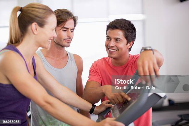 Photo libre de droit de Homme Aidant Femme Avec Un Tapis De Course Dans La Salle De Sport banque d'images et plus d'images libres de droit de 20-24 ans