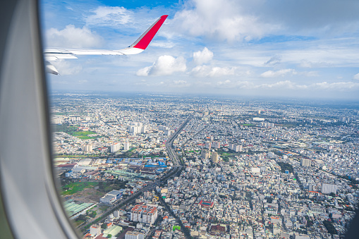 Looking from above the landscape of Ho Chi Minh City in Vietnam through the plane window when approaching the airport