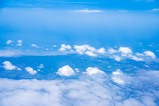 Background blue sky and white clouds seen from plane window. There is space for writing content. Natural sky, bright style.