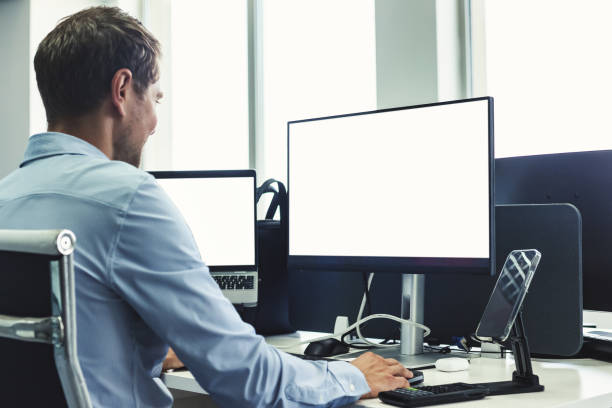 istock Young man manager businessman broker agent in blue shirt working in corporate office using pc computer at desk, rear view. Concept of business development growth, solutions. Copy ad text space 1669366331