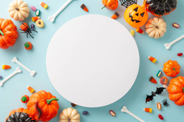 istock Halloween-themed elements, mini pumpkins, bones, jelly candies, candy corn, spiders, insects, bat on soft blue backdrop with empty circle, ready for greetings or ads 1669373510
