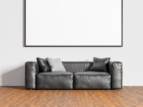 Background image of a sofa against the wall in the living room with empty picture frames on the wall