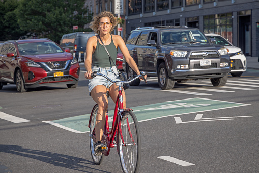 11th Street, Long Island City, Queens, New York, USA - August 19th 2023: Young woman in the traffic in the afternoon summers sun