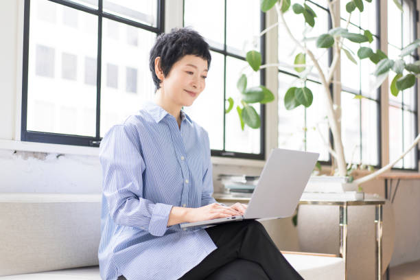 アジア人女性がラップトップで作業しています。 - 良い ストックフォトと画像