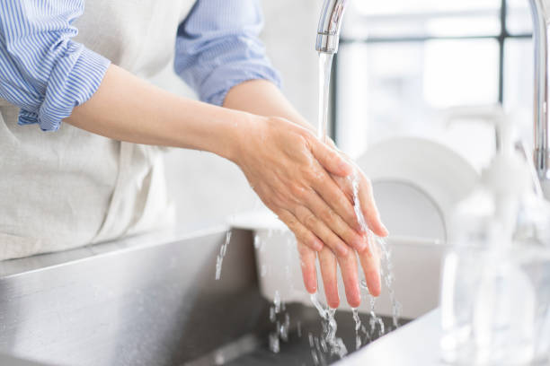 istock A woman is washing her hands in the kitchen. 1669474736