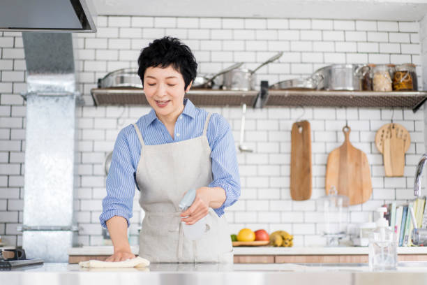 eine frau wischt die küchentheke ab. - cleaning domestic kitchen counter top housework stock-fotos und bilder