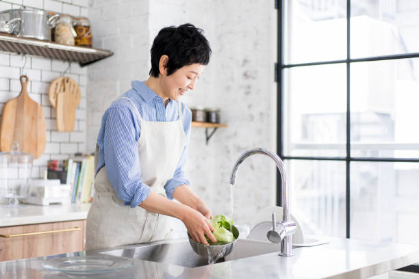 istock An Asian woman is washing vegetables. 1669475816