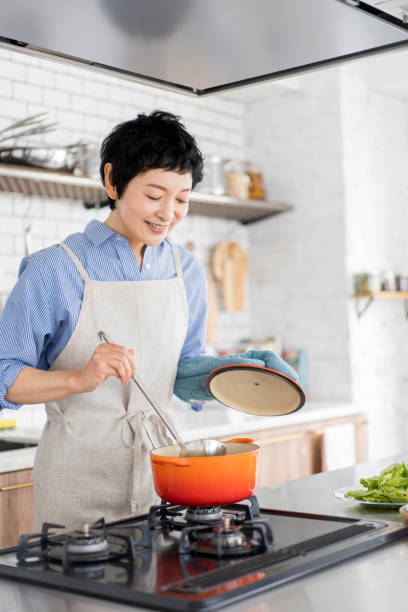 An Asian woman is cooking.