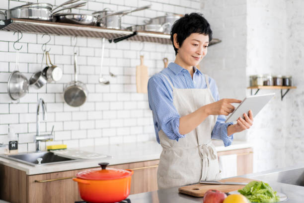 istock A woman cooks while looking at a tablet. 1669476846