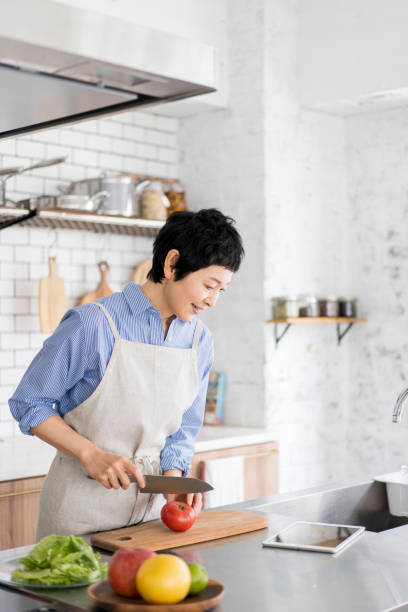 istock A woman cooks while looking at a tablet. 1669476852