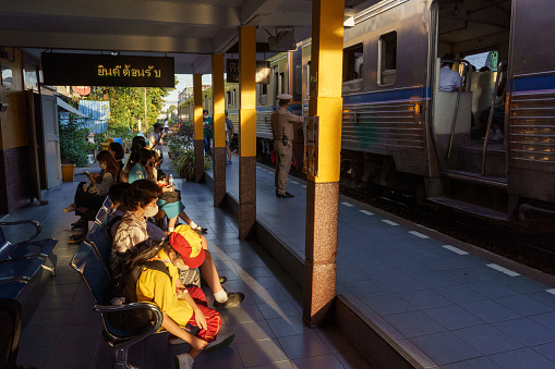 Bangkok, Thailand - January 4 2023 : A crowd waits for an upcoming train at the train station in Wongwian Yai