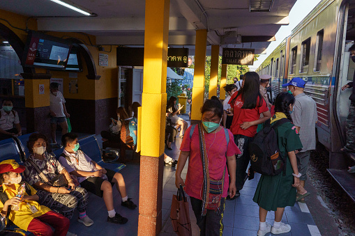 Bangkok, Thailand - January 4 2023 : A crowd waits for an upcoming train at the train station in Wongwian Yai