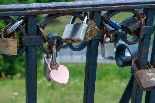 Pink lock in the shape of a heart. Locks for happiness, love and luck. Ritual and superstition. Tourist travel embankment. Heart lock copy space background.