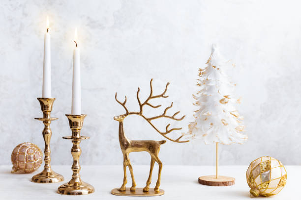 パステルの明るい背景に居心地の良い静物と燃えるろうそく、鹿の姿、クリスマスの飾り。家のインテリアのためのクリスマス構成
.