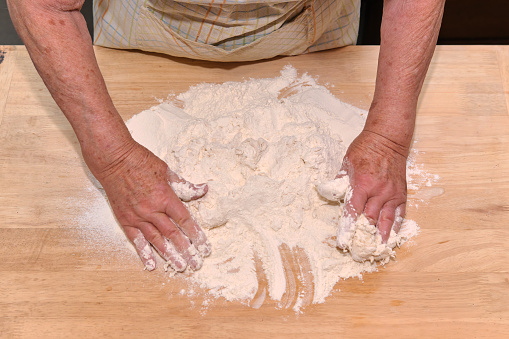 Baker kneading artisan bread in the bakery