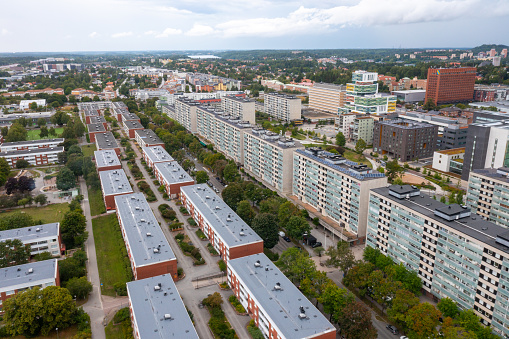 From an aerial vantage point, the apartment complexes along Malmvägen in Sollentuna come into sharp focus. These multi-story buildings, with their well-defined structures, exemplify modern urban residential design. Nestled amid green spaces and interconnected by well-maintained roads, the entire scene reflects a thoughtful approach to urban planning and community living.