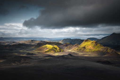 Amazing dramatic volcanic landscape in Landmannalaugar area (Central Highlands, Iceland). Few mountains are illuminated by the sunlight.