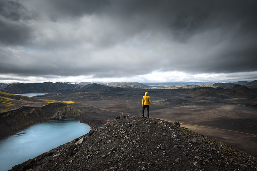 Man standing on top of Blahylur crater lake in the south highlands of Iceland.