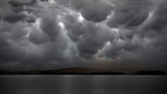 A dramatic stormy lake sky and the waters below highlight this AI generated image.