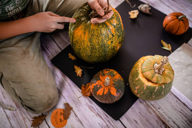 istock young artist's hands transform the pumpkin into a Halloween work of art. 1669704006