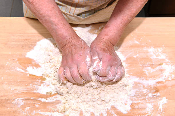 Grandmother's hands on bread dough - home baking