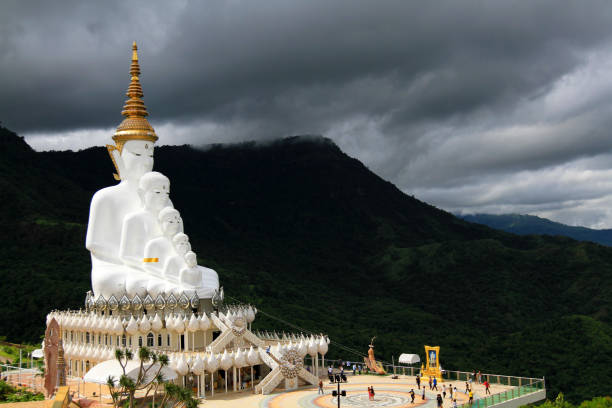 istock Big white monk statue with green mountain, sky and white cloud background with copy space at Thai temple Phetchabun, Thailand. Landmarks and famous place for travel. 1669767619