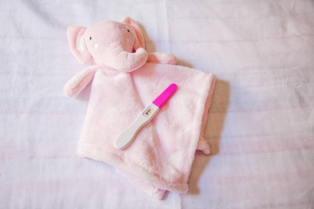 Side view of a woman holding a pregnancy test in her hand, representing a health and family planning moment.