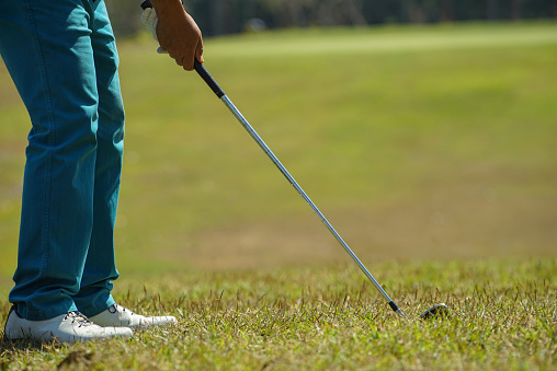 Woman hands hold clubs golf equipment on field. Active golfer using putter bag on meadow close up. Unknown professional player play competition golfing game. Luxury sport activity outside concept.