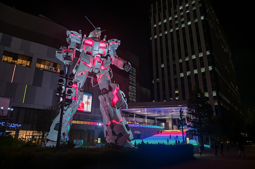 Tokyo, Japan - April 28, 2023: Gundam, real size model, light up at Divercity Tokyo plaza at night in Oodaiba area.