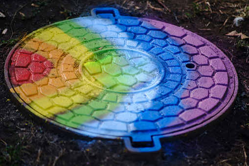 Rainbow manhole cover in the garden. Selective focus.