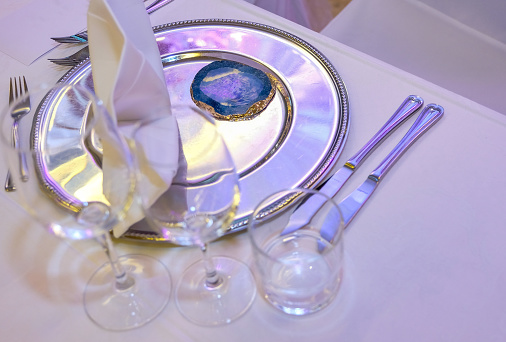 Festive table setting. Glasses and metal dish.