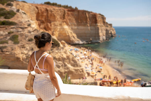 istock Woman watching the beach in summer 1669884872