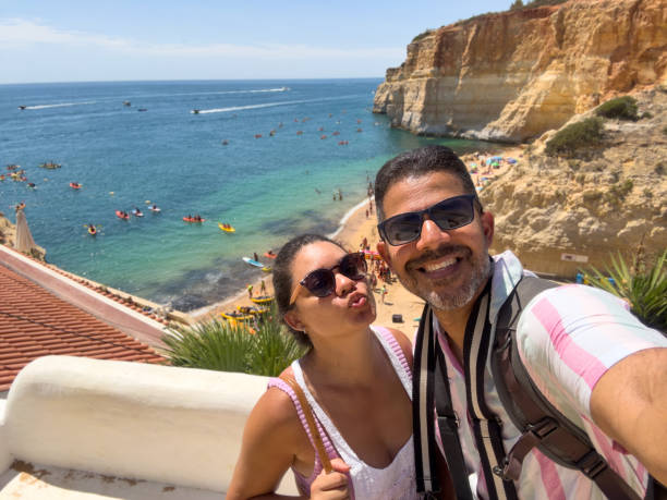 istock Couple taking a selfie on honeymoon at the beach 1669886029