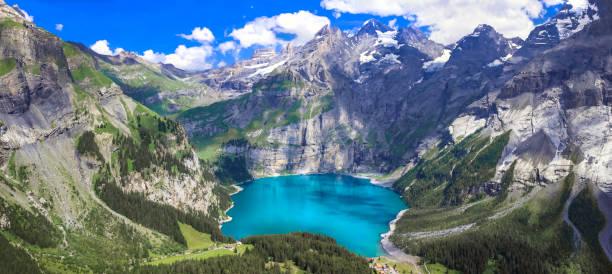 カンデルシュテーク村の空中高角度ビュー近くのアルプス山脈のターキーズ水と雪に覆われた山頂を持つ牧歌的なスイスの山湖oeschinensee(oeschinen)。スイスの自然の風景 - european alps mountain beauty in nature oeschinen lake ストックフォトと画像