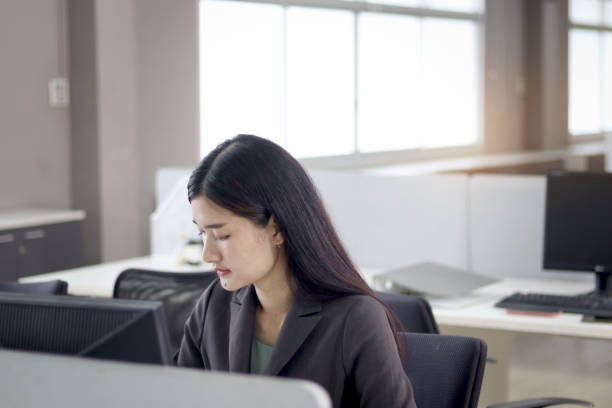 istock Serious beautiful Asian woman officer typing desktop computer while sitting at office desk. Concentrate female worker working at workplace, hardworking and busy office lady employee staff at office. 1669904123