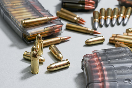 Bullet cartridges and transparent ammunition magazine, close up photo
