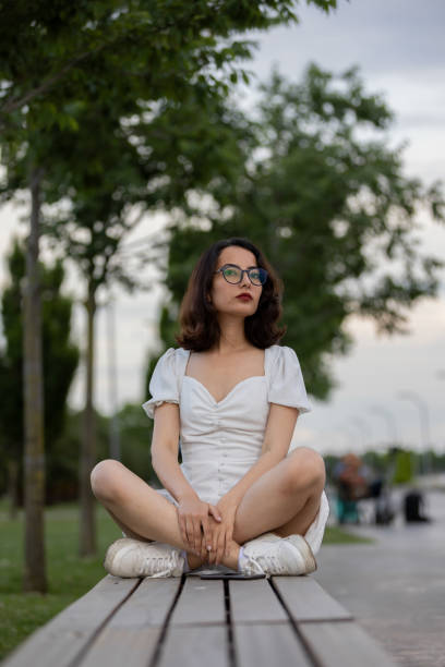 istock Young woman is sitting on the park bench. 1669922425