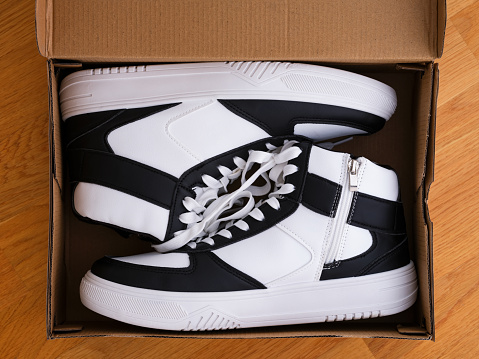 Two white and black shoes in a shoebox